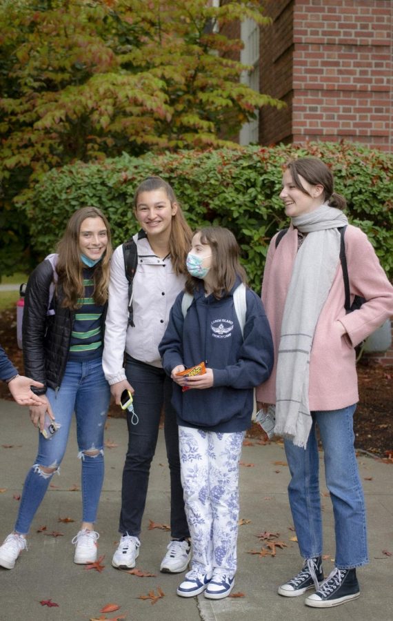 Julia B. ’24 in ripped jeans and green stripes—an incredible combo; Audrey D. ’24 in a white windbreaker and dark-wash jeans; Sadie D-S. ’24 wearing patterned pants and Nikes color-coordinated with her navy blue sweatshirt; Darby C. ’24  in jeans, converse, a popping pink jacket, and an elegant scarf. 