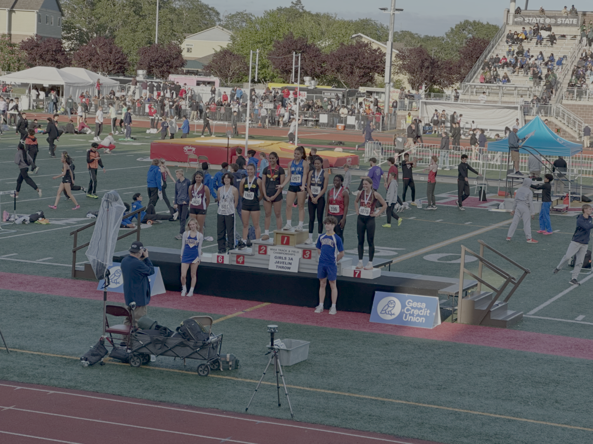 Anvi B. ’27, standing above on the leve-2 pedestal after breaking her personal
best by 1.6 meters to win silver at the Washington 3A State Track Meet.